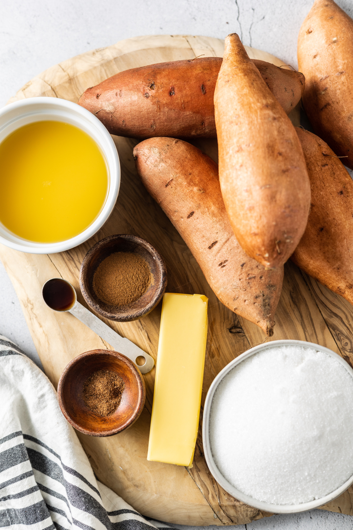 sweet potatoes, vanilla, sugar, butter, cinnamon, nutmeg, and orange juice on a cutting board