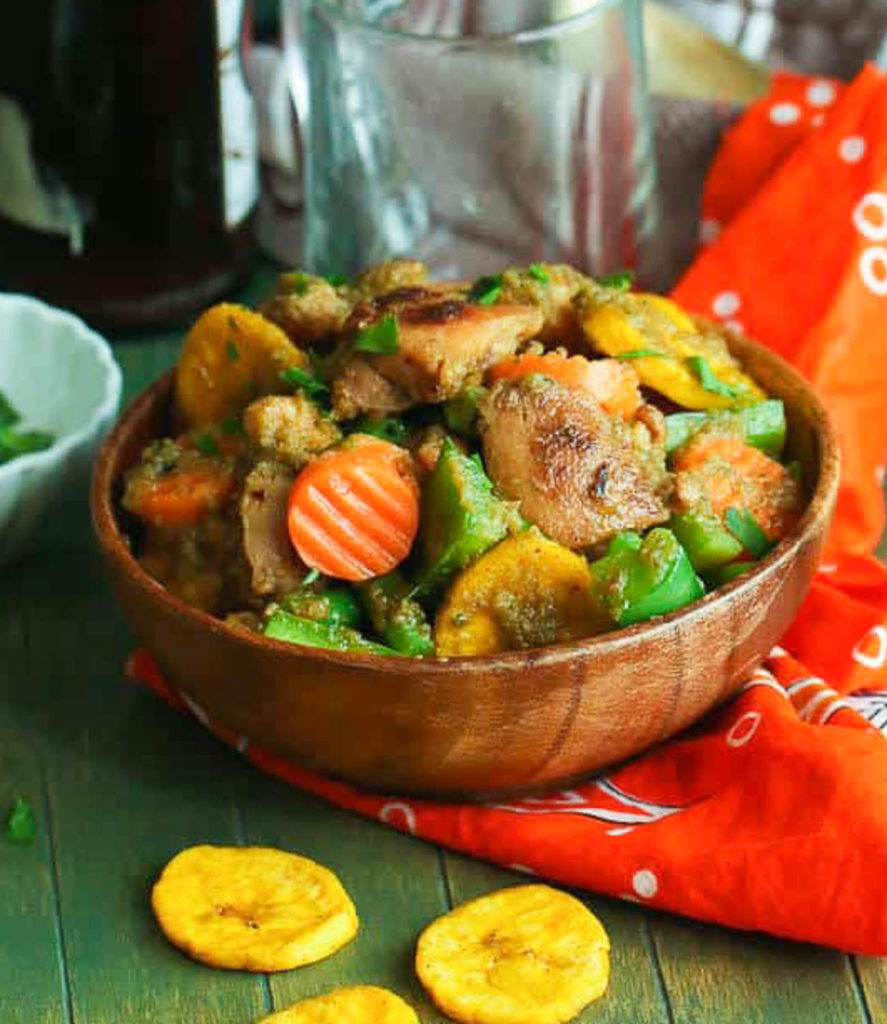 Poulet DG with plantains and carrots in a beautiful wooden bowl.