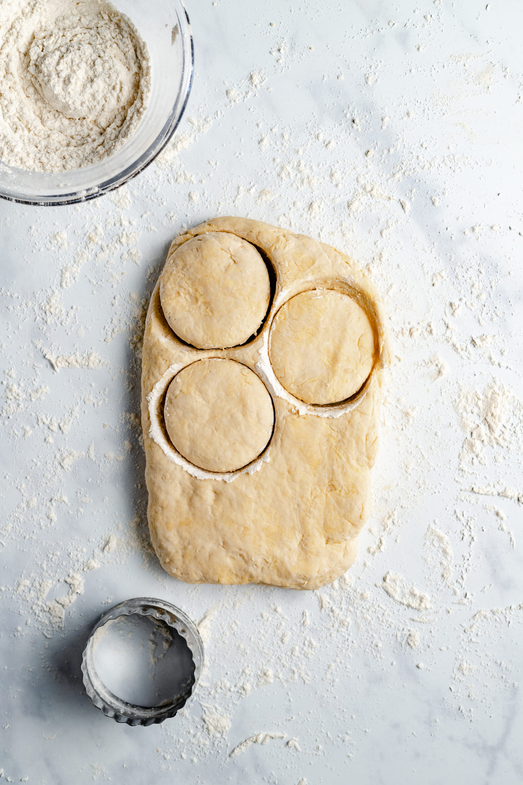 Vegan Biscuit Dough on a Floured Surface with Three Biscuits Cut Out