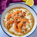 black folks shrimp and grits on a plate with bacon