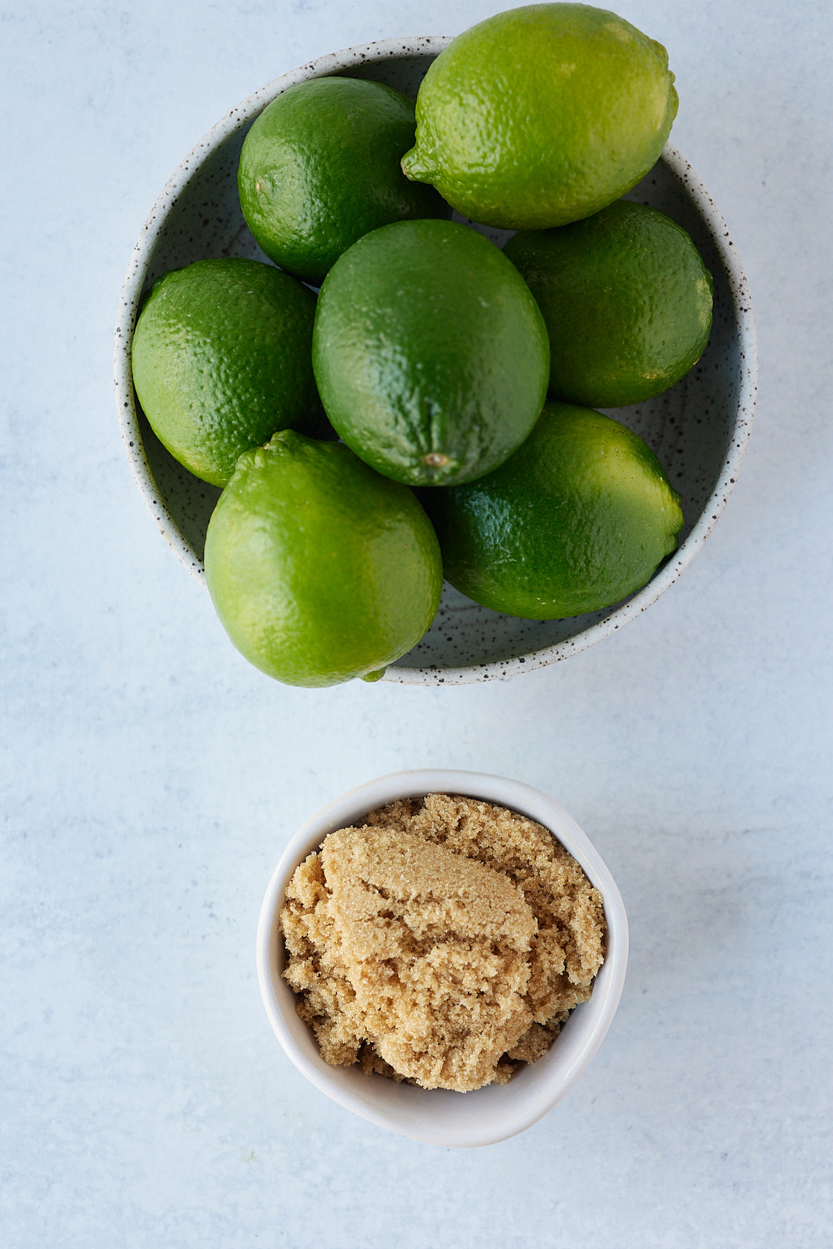 brown sugar and whole limes on ablue background