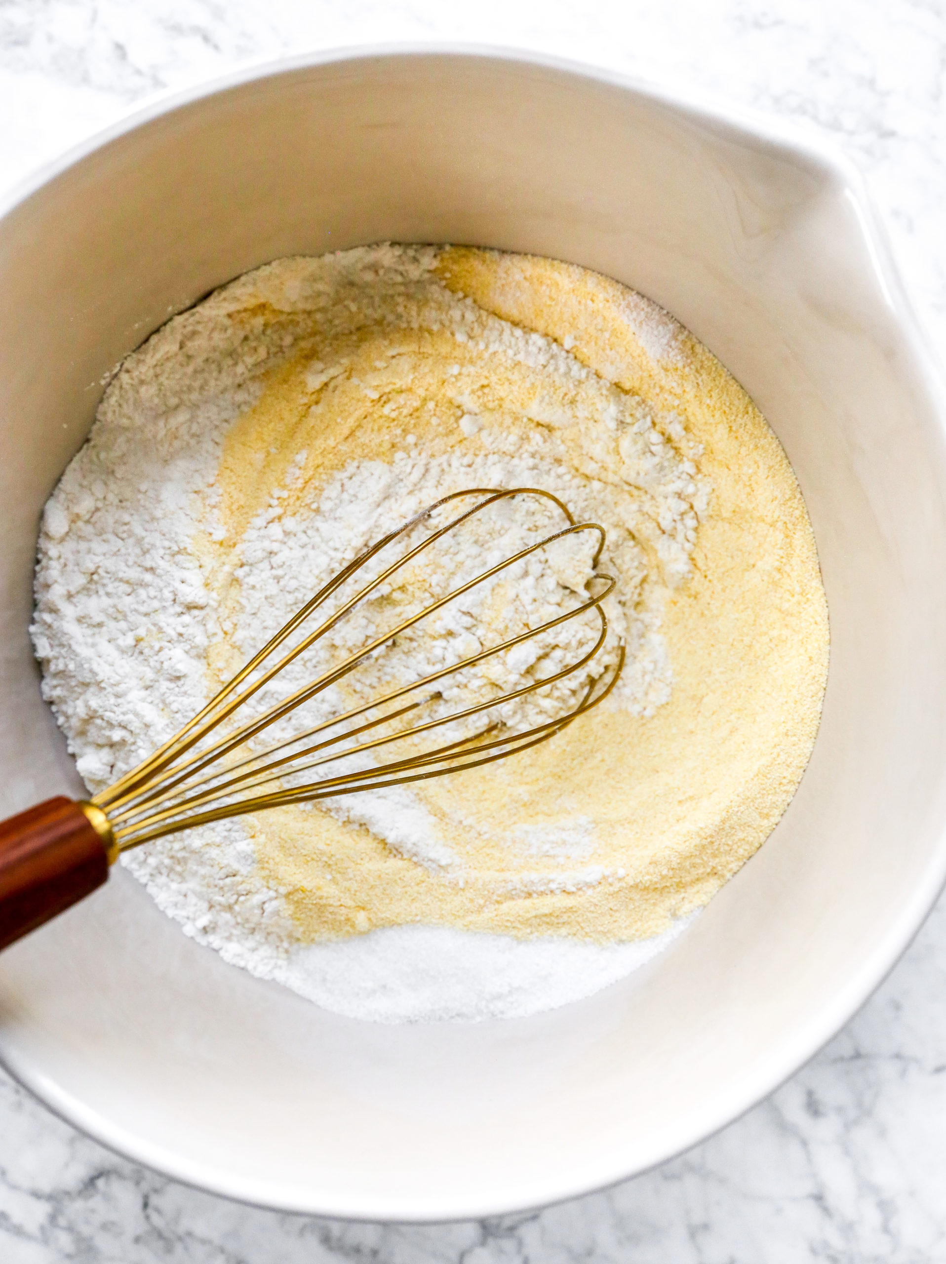 Whisking dry ingredients in a bowl.