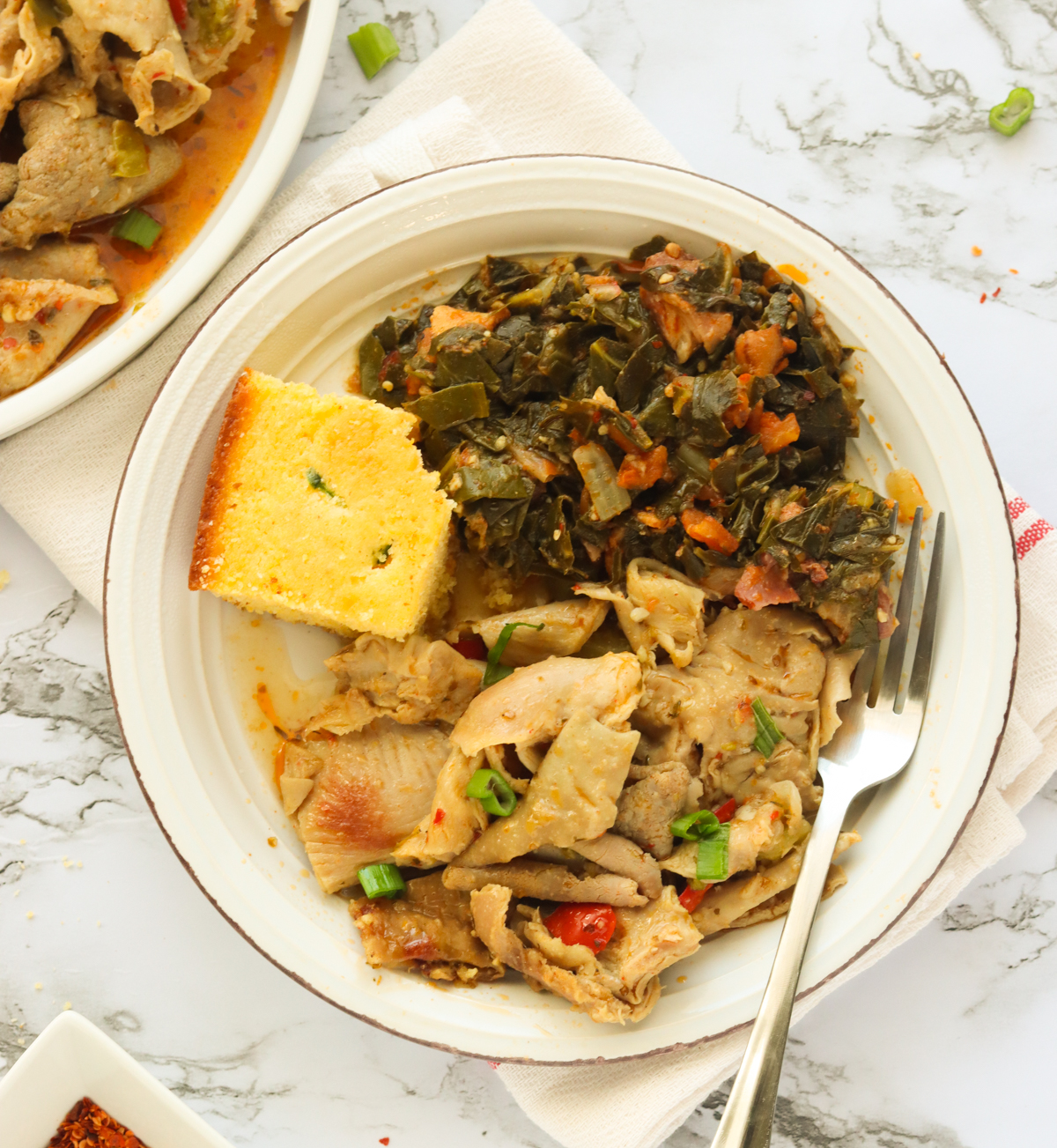 Chiltins with collard greens and cornbread in a white bowl