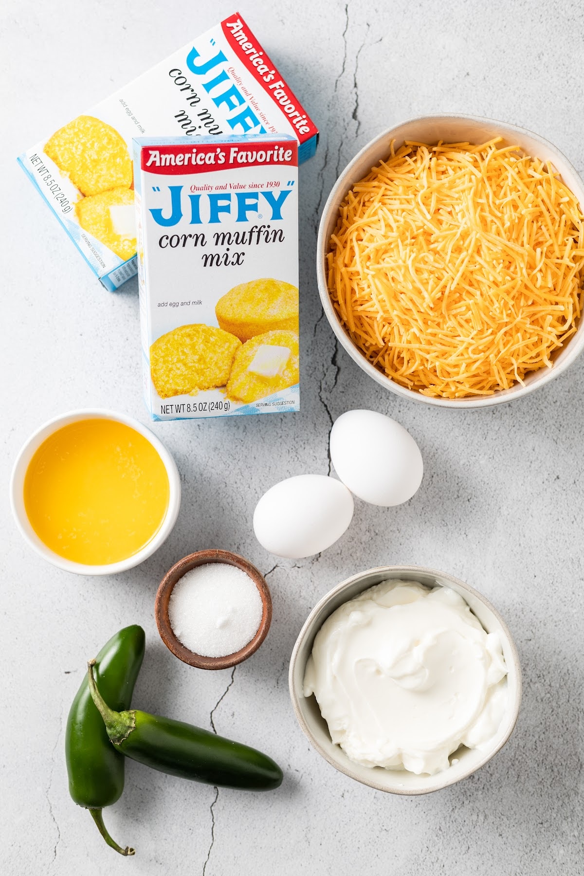 jiffy cornbread muffin mix, cheddar cheese, butter, sour cream, jalapeño and eggs in separate bowls