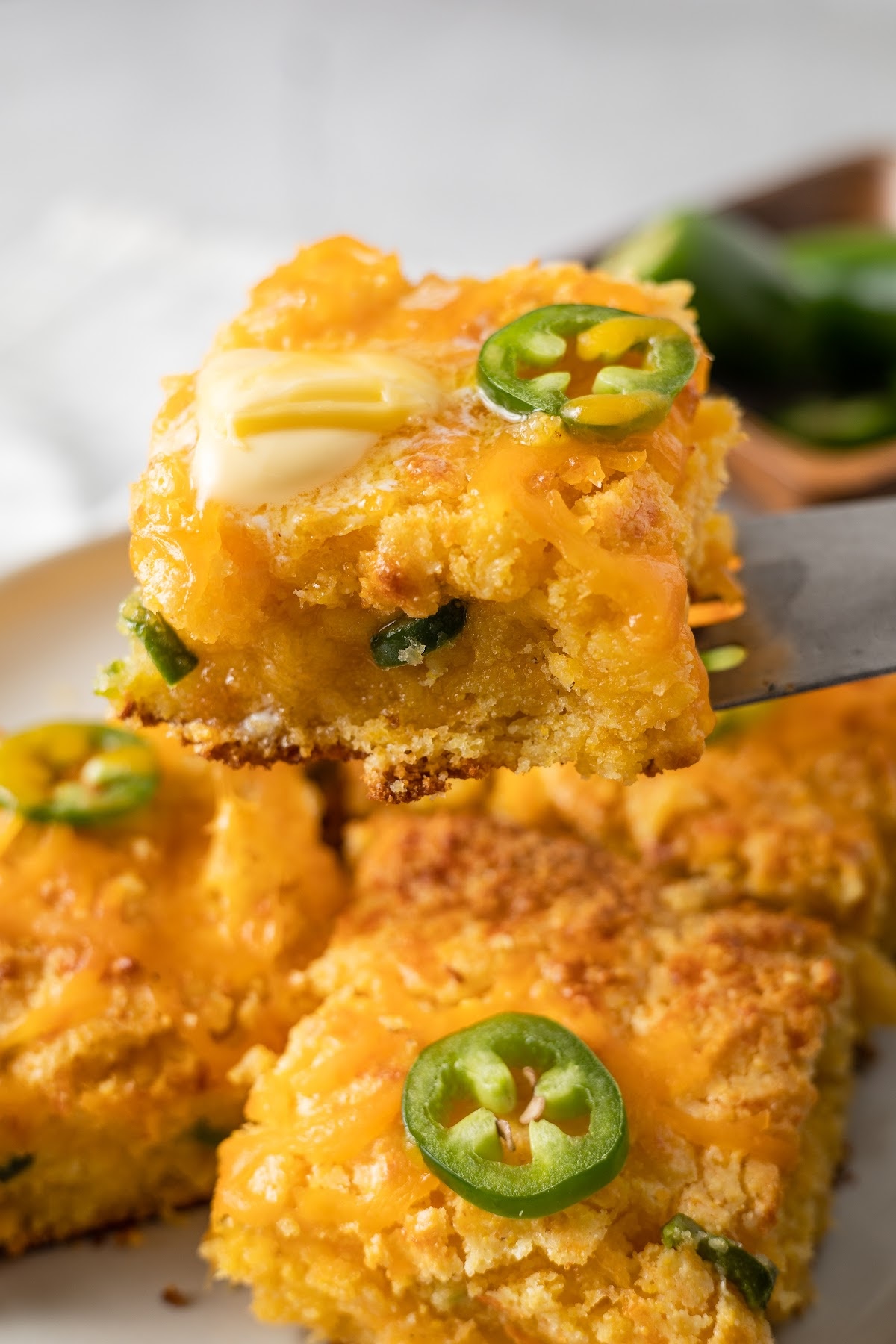 a plate of jiffy jalapeño cheddar cornbread slices with butter on top