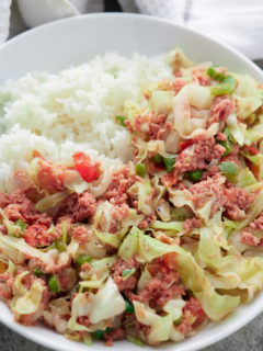 jamaican corned beef and cabbage on white plate with white rice