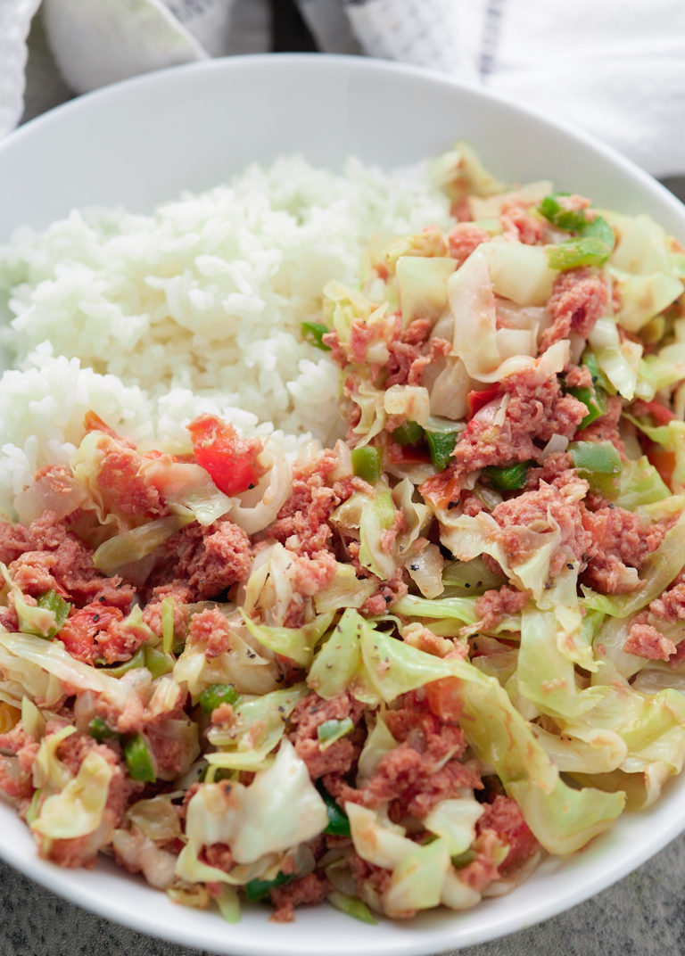 jamaican corned beef and cabbage on white plate with white rice