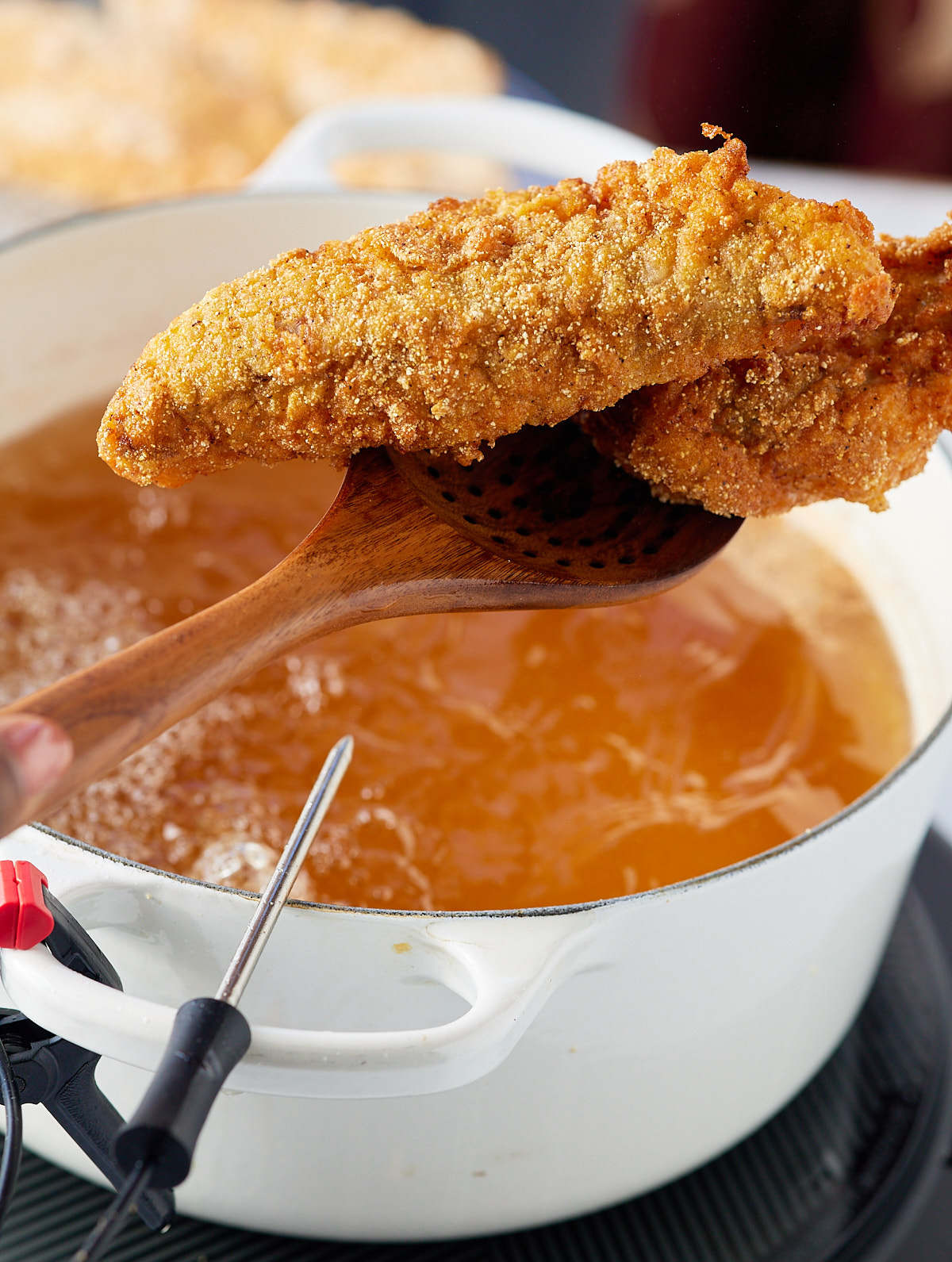 fried catfish being lifted out of oil