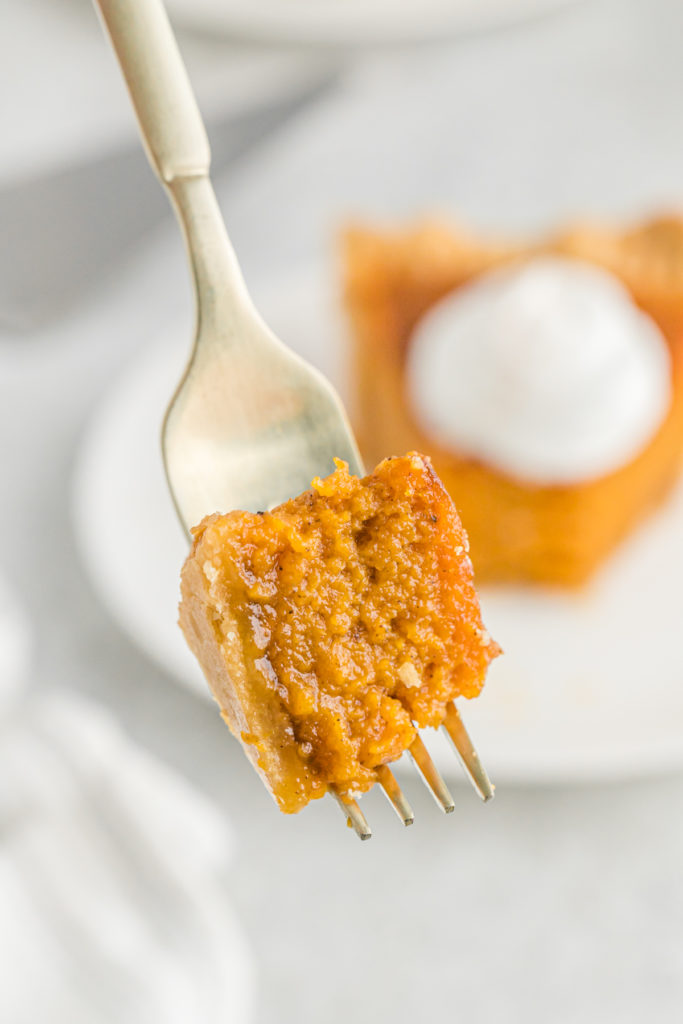 A close up of a piece of Patti Labelle's Sweet potato pie on a gold fork.