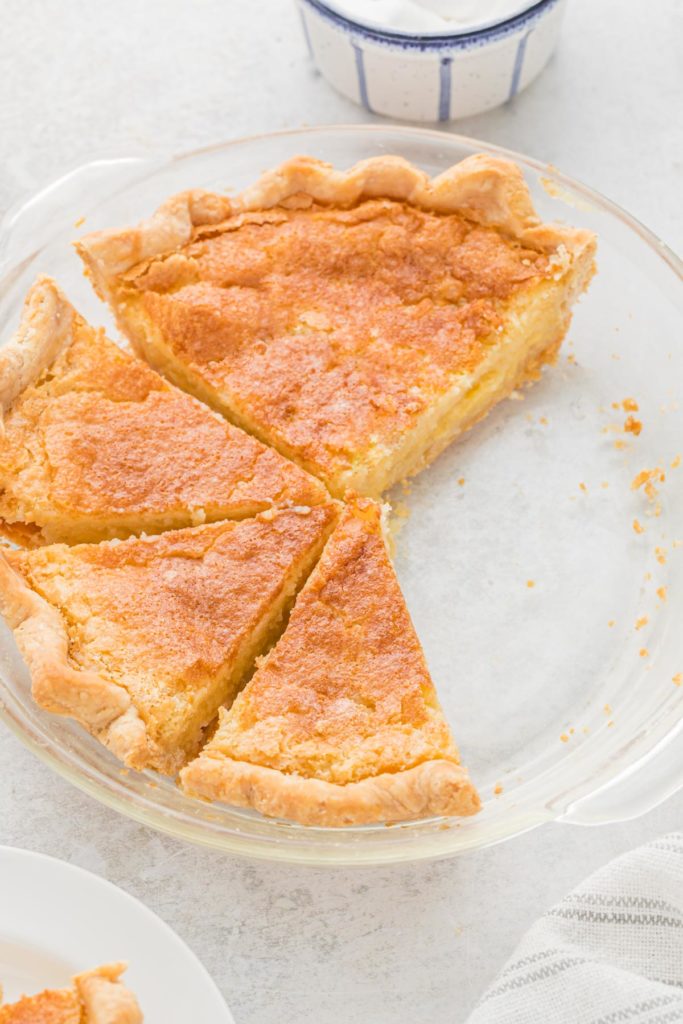 A buttermilk pie sliced against a white background