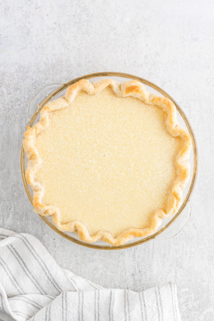 A pie crust filled with a pie filling before baking.