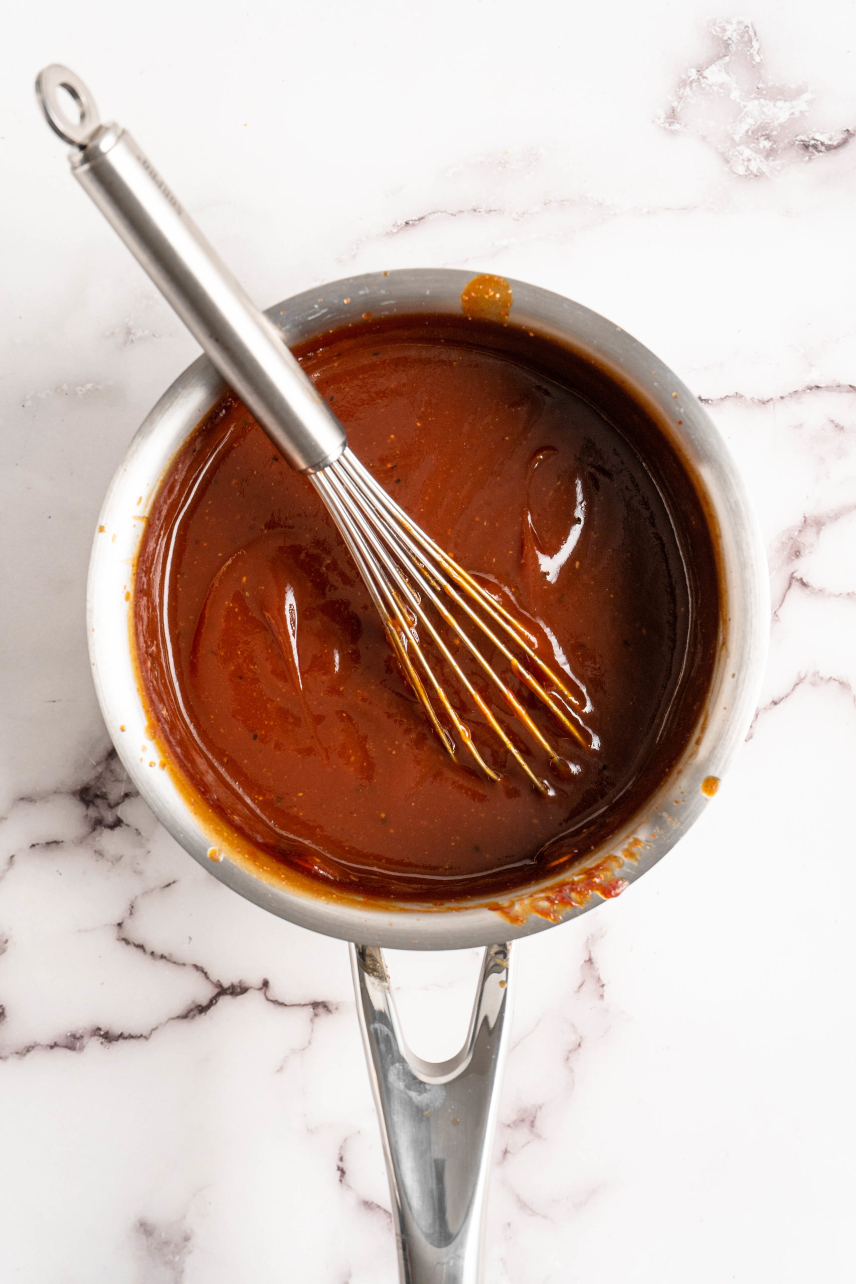 Whisking barbecue sauce in saucepan