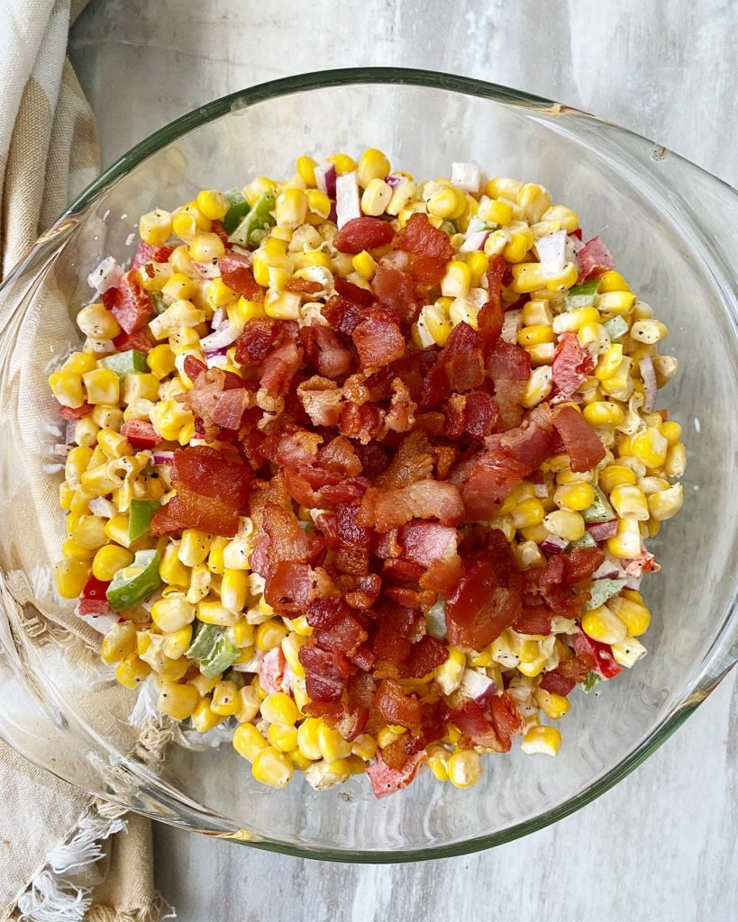close up of southern corn salad in a bowl with bacon on top