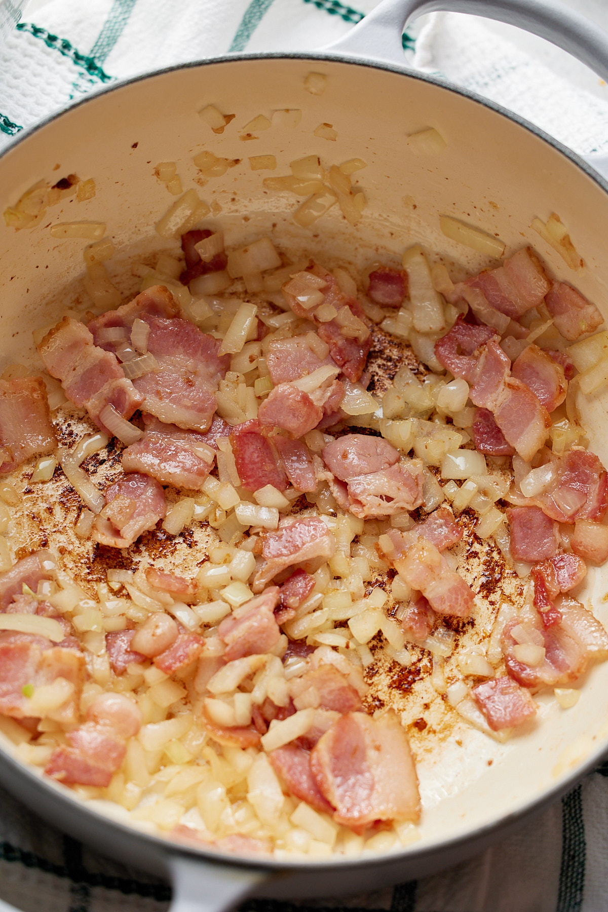 bacon and onions cooking in heavy bottomed pot