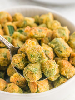 A close up of fried okra with a spoon taking some out