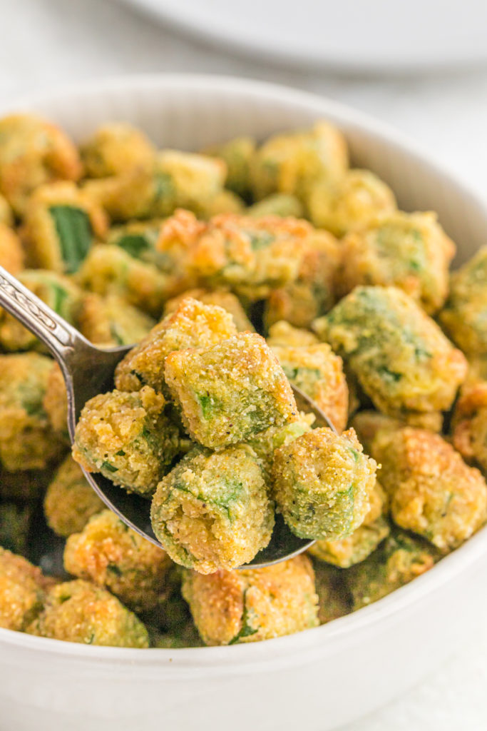 A close up of a bowl of fried okra recipe in a white bowl ready to serve.