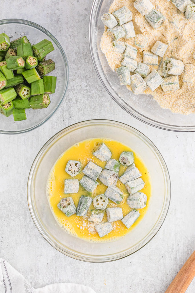 Breaded okra in an egg bath before frying.