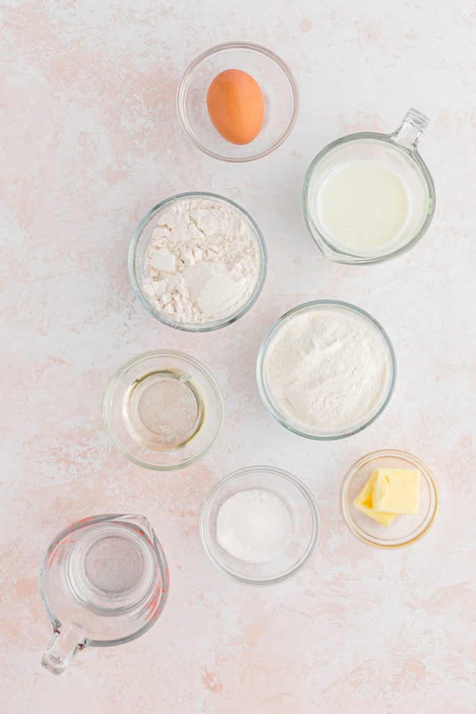 An overhead of ingredients to make southern pancakes against a marble background