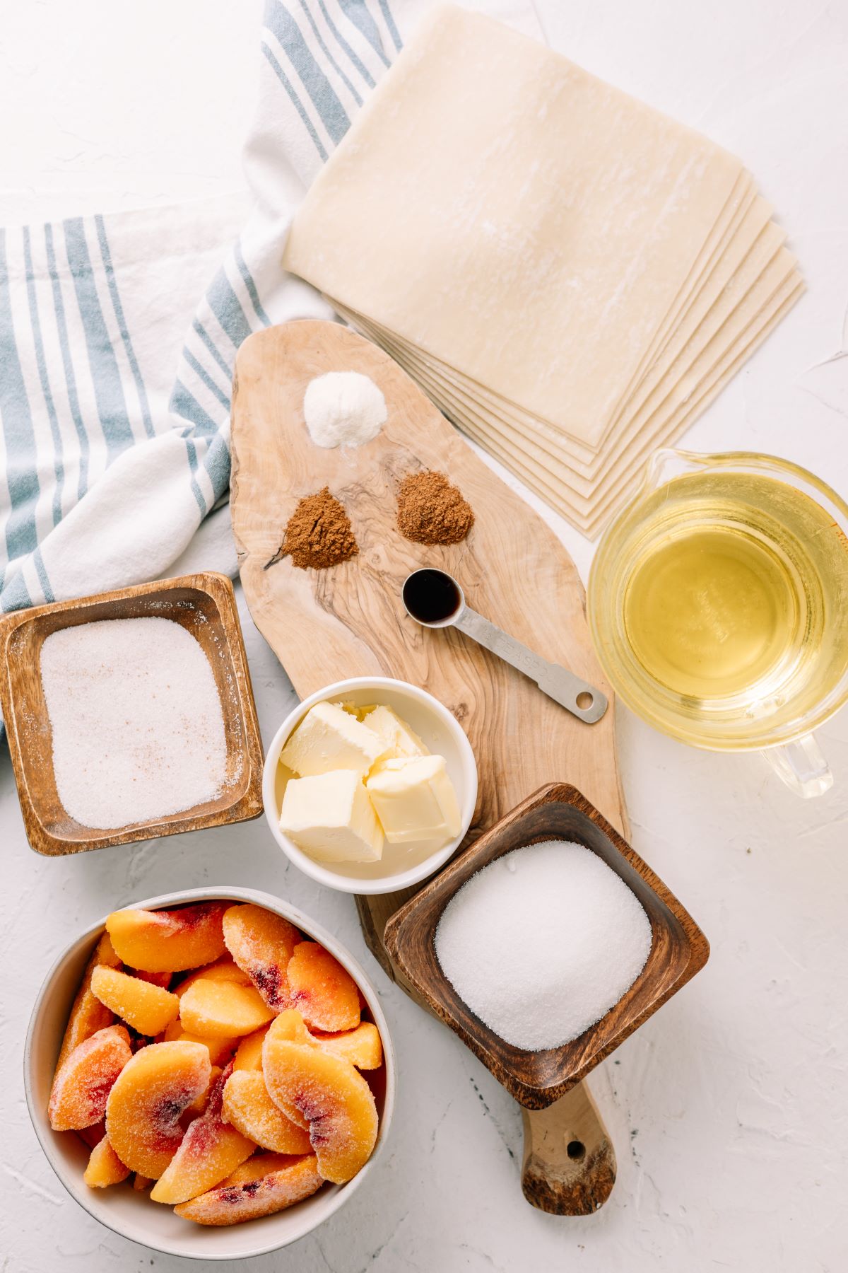 frozen peaches, nutmeg, oil, butter, sugar and other ingredients on separate bowls