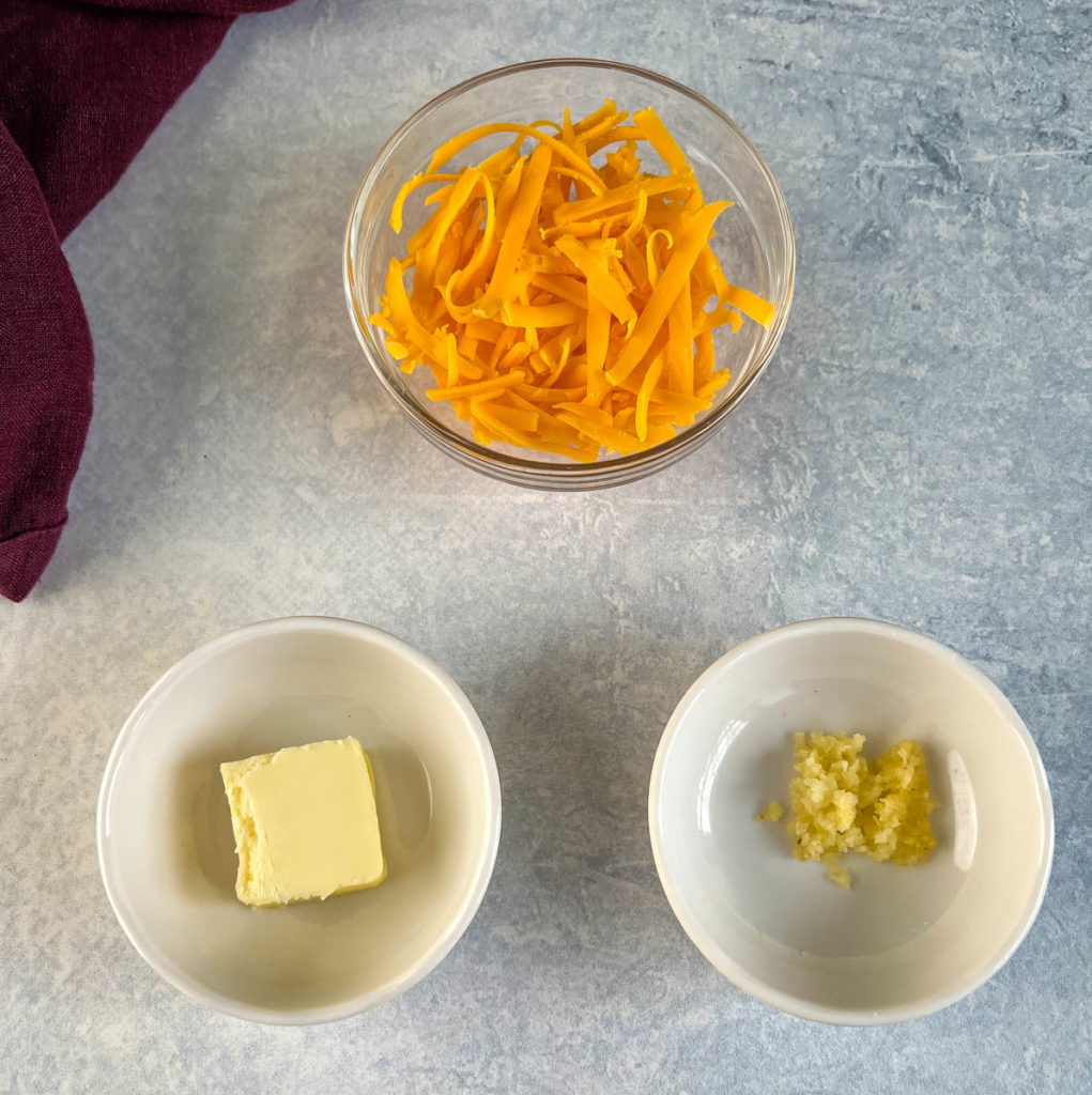 cheddar cheese, butter, and garlic in separate bowls