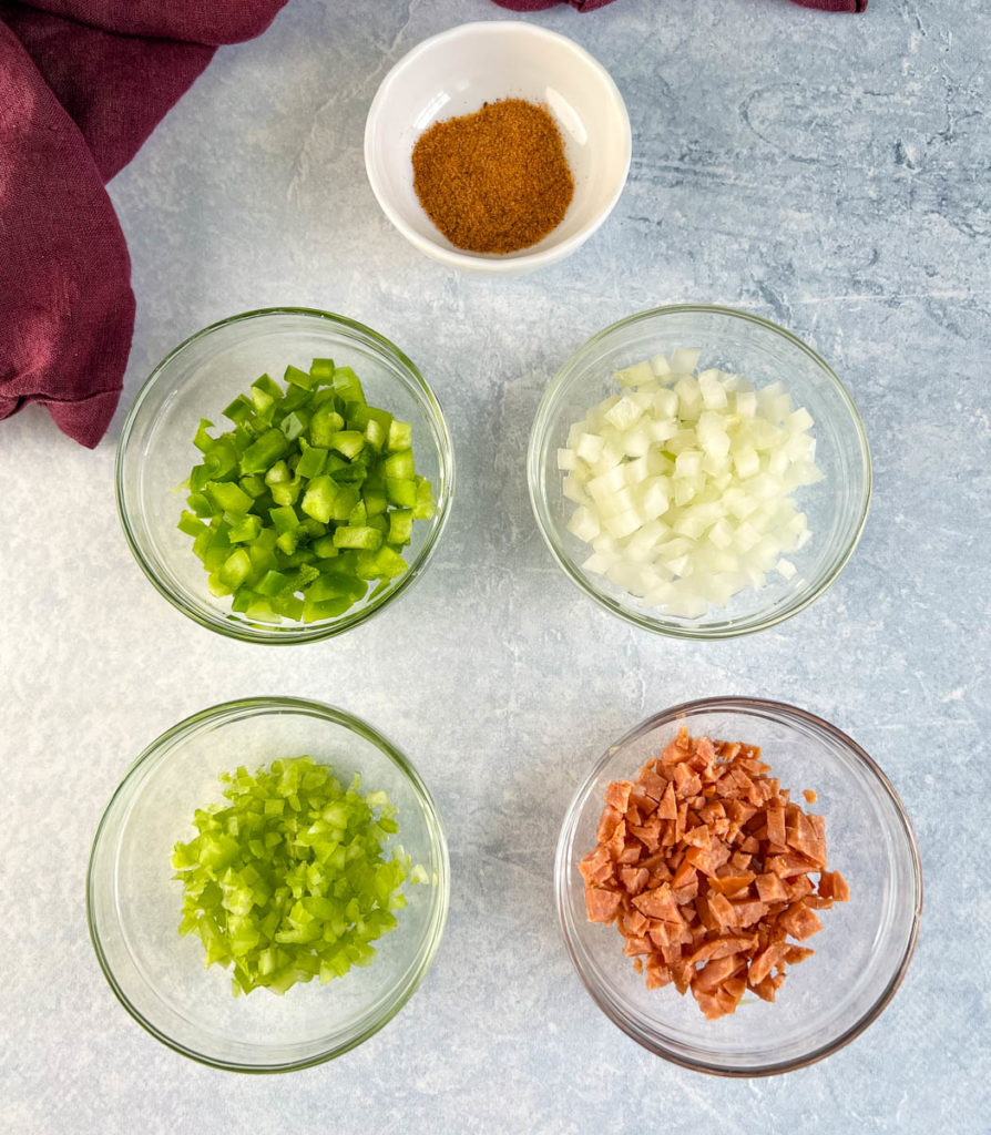 chopped green peppers, celery, onions, sausage, and Cajun seasoning in separate bowls