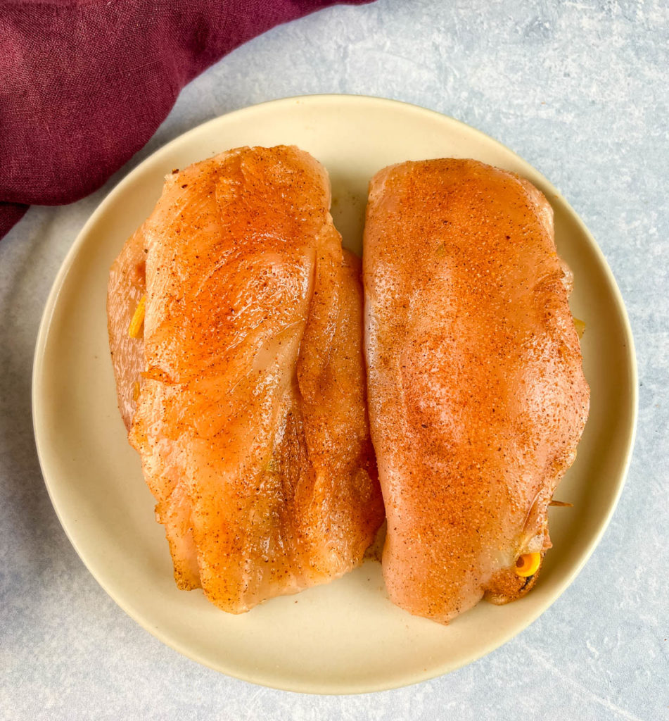 raw cajun seasoned stuffed chicken breasts on a plate