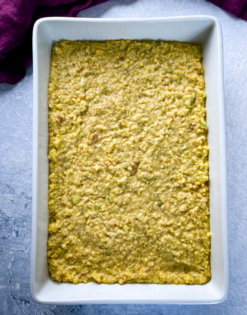 unbaked cornbread dressing in a white baking dish