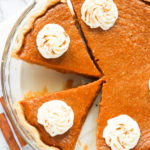 Sliced sweet potato pie topped with whipped cream