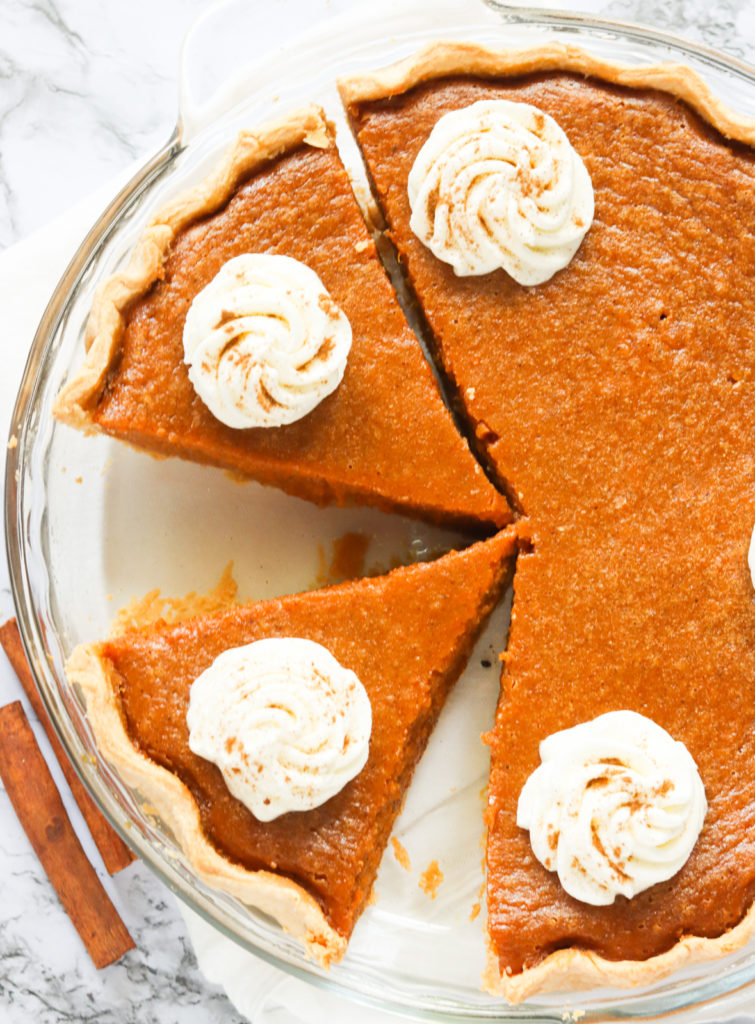 Sliced sweet potato pie topped with whipped cream