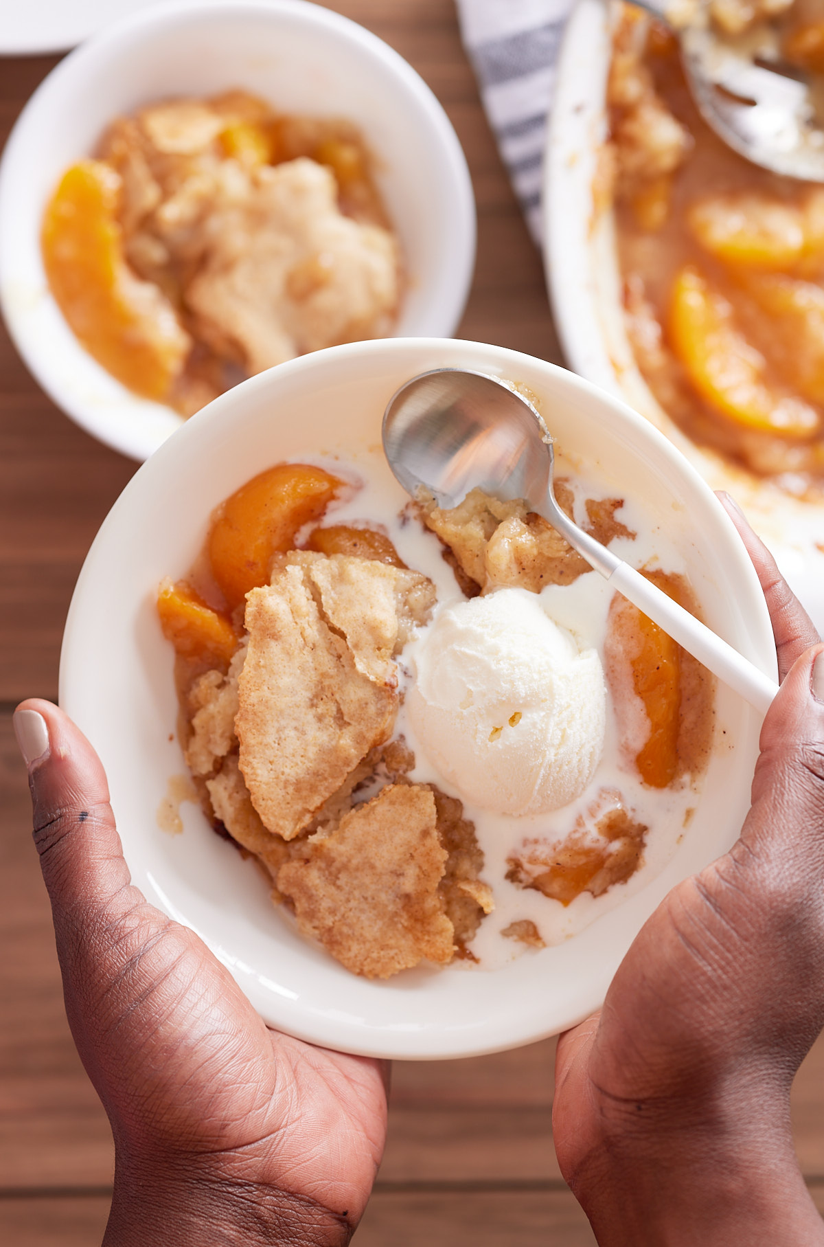 hand holding up peach cobbler with canned peaches