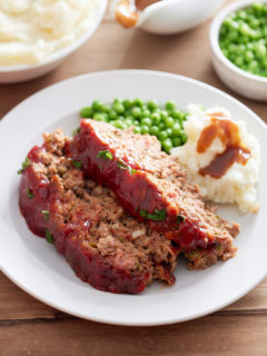 meatloaf on plate with mashed potatoes and gravy on side