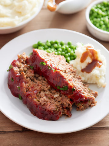 meatloaf on plate with mashed potatoes and gravy on side