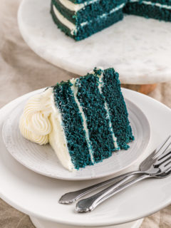 A slice of blue velvet cake on a white plate ready to serve