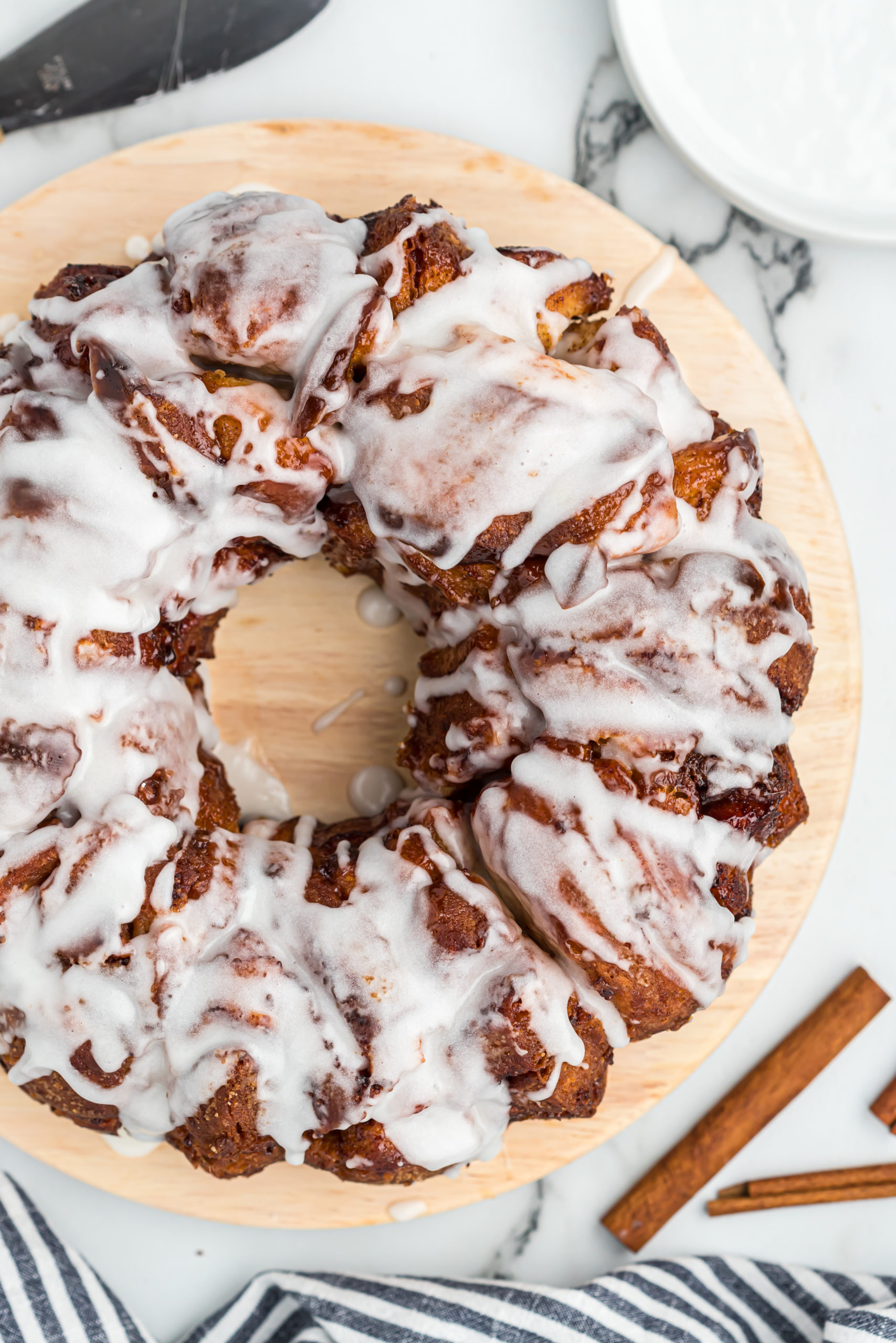 A delicious close up of a cinnamon roll monkey bread with vanilla icing on top ready to serve