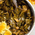 Overhead view of vegan collard greens in bowl with spoon