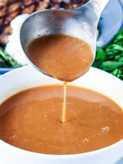 Creamy brown gravy drizzling from the spoon