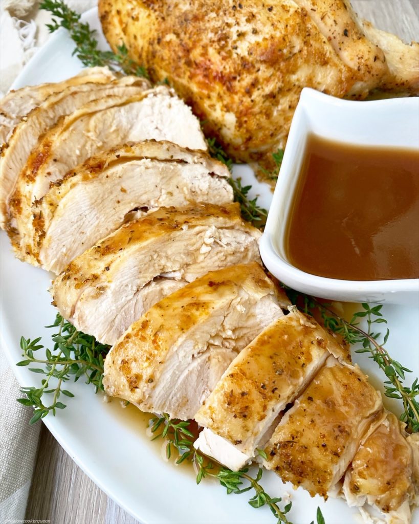 sliced, turkey breast with gravy on a white plate
