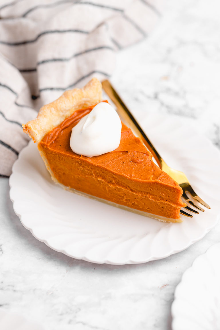 Slice of vegan sweet potato pie on plate with gold fork