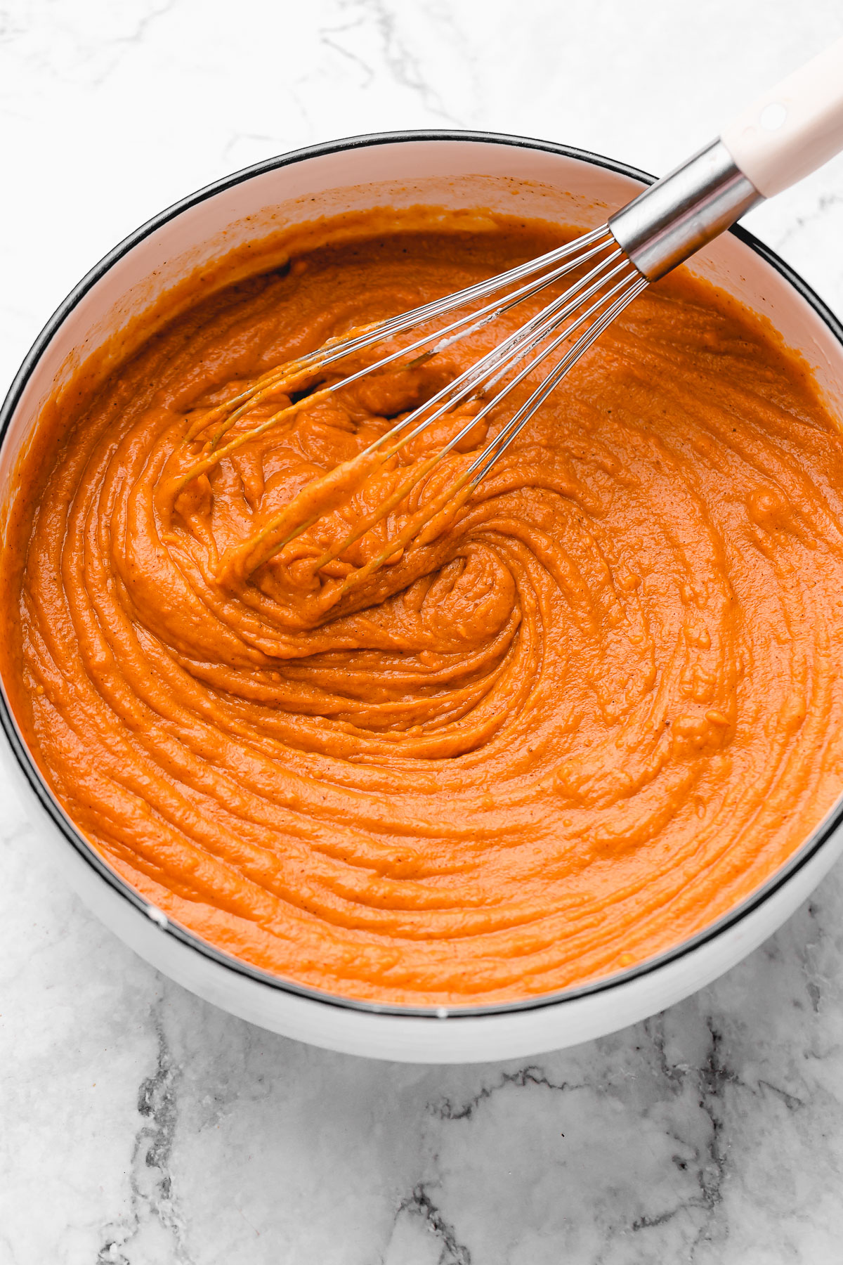 Sweet potato pie filling in bowl with whisk
