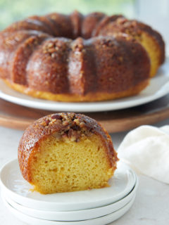 slice of bicardi rum cake on white plates with whole cake in background