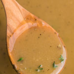 A wooden spoon lifting gravy