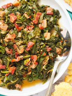 A plateful of mustard greens and bacon with a spoon