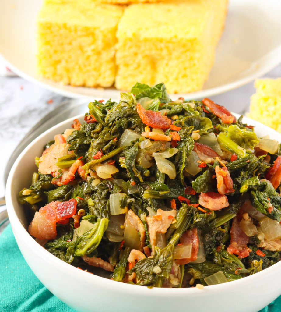 Mustard greens with bacon and fresh cornbread in the background