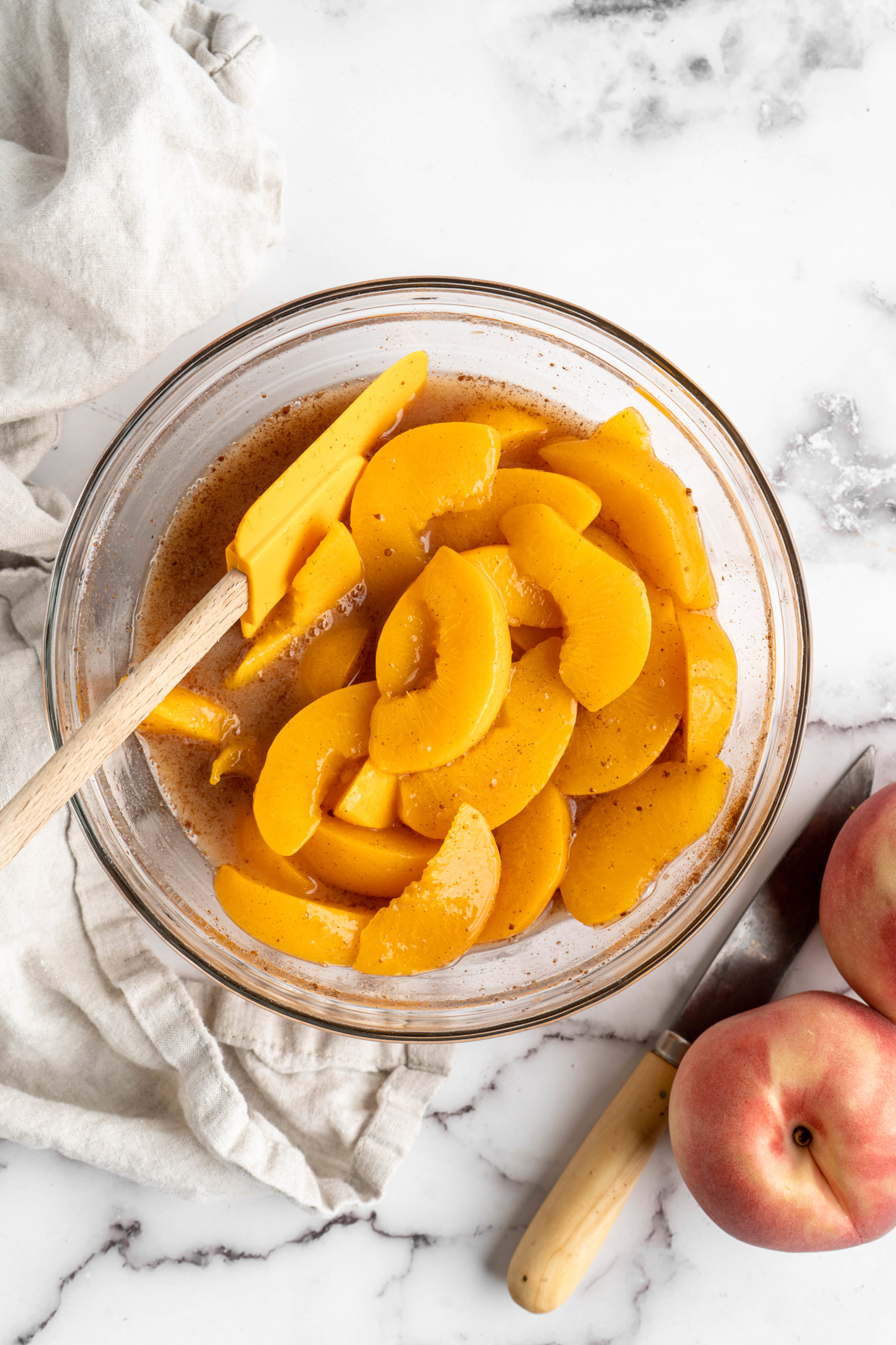 Overhead view of peaches in glass mixing bowl