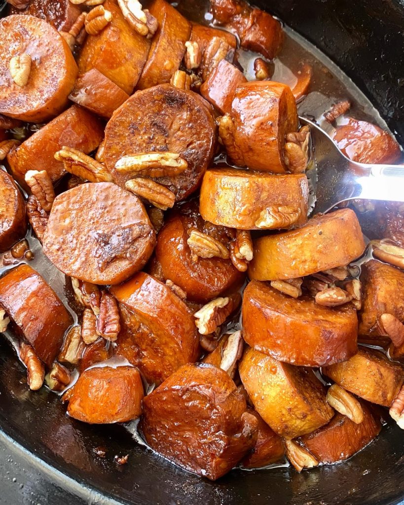 slow cup of sweet potatoes in the slow cooker with chopped pecans on top