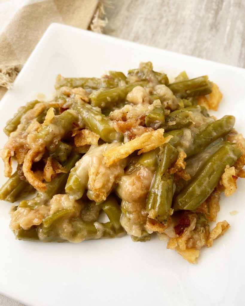 close up of green bean casserole on a white plate