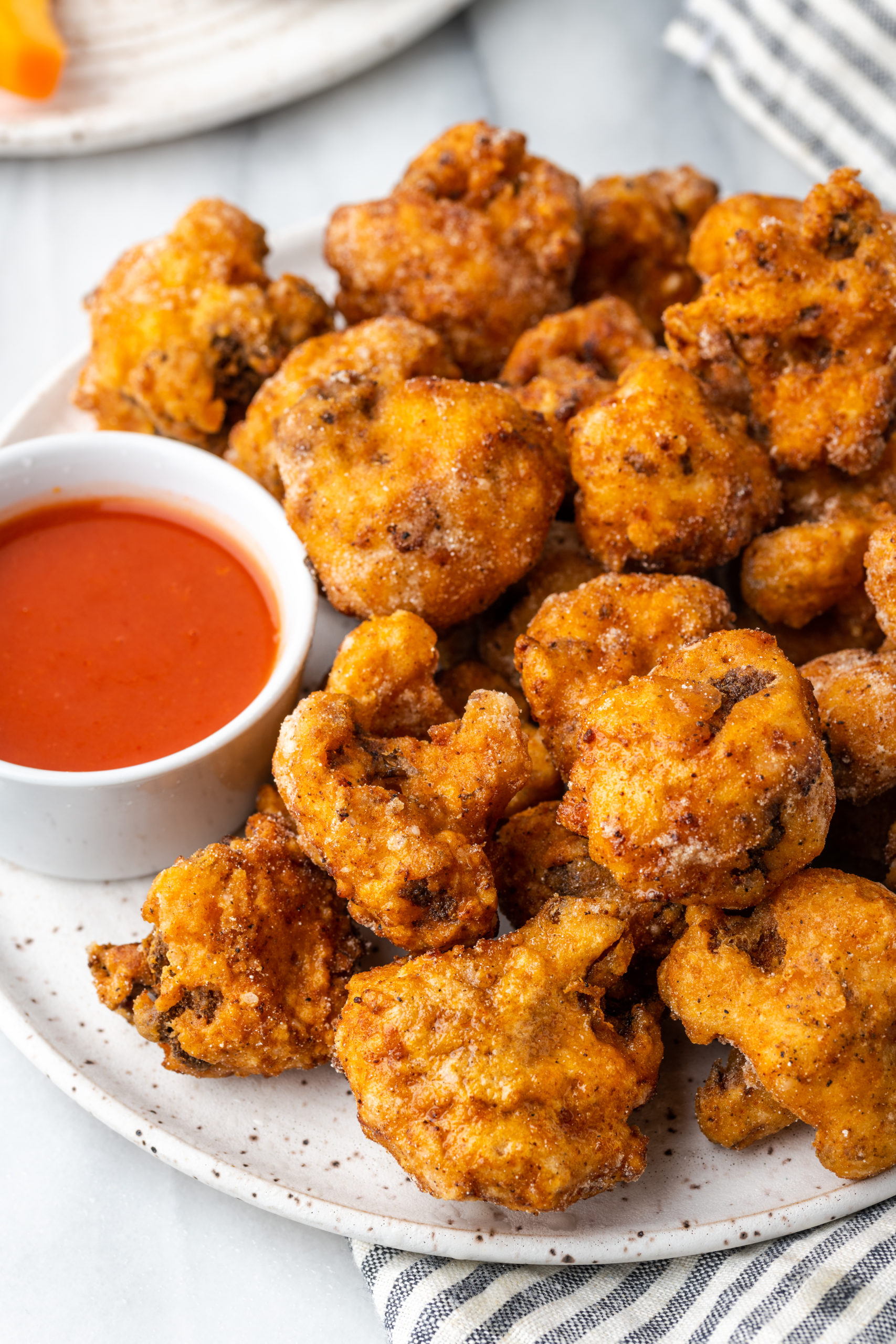 Southern Fried Cauliflower on a plate with hot sauce
