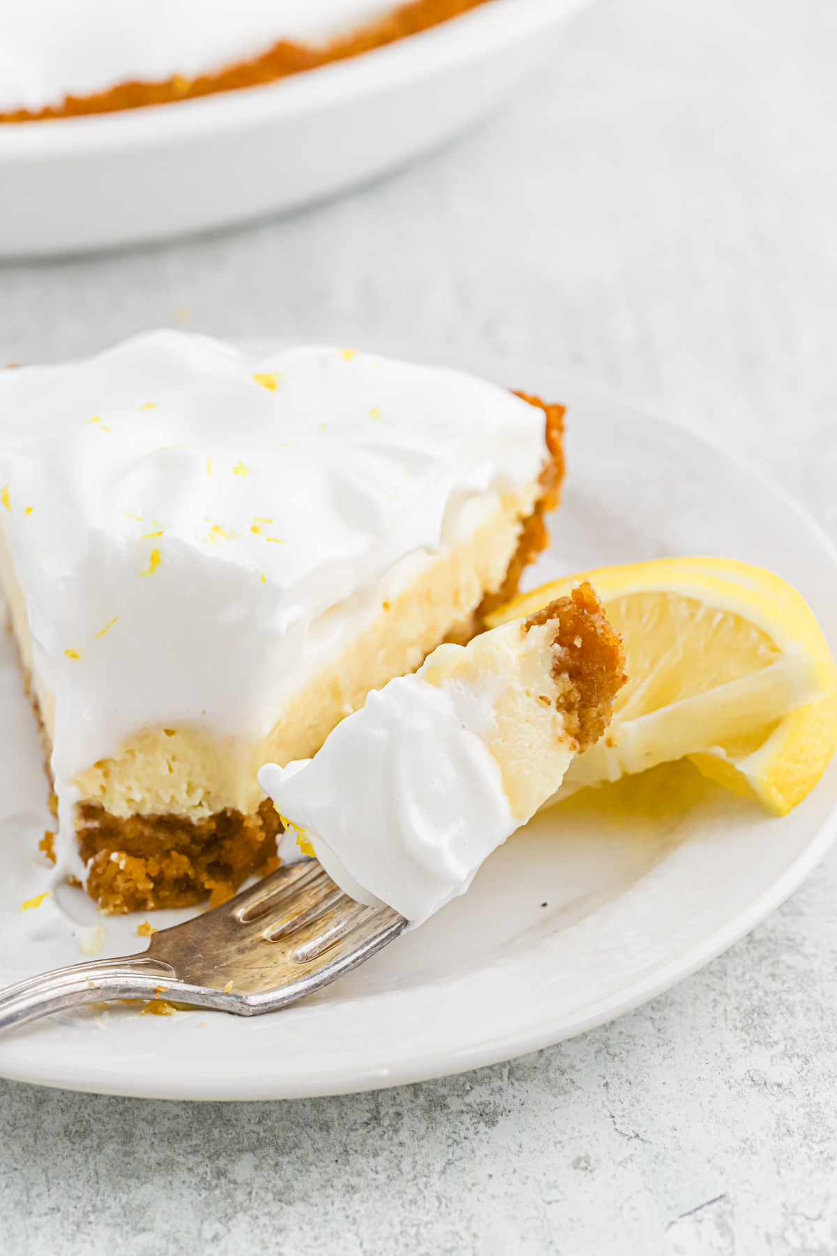 A slice of lemon icebox pie recipe with a piece on a fork
