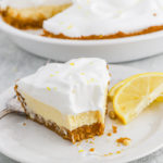 A slice of lemon icebox pie on a white plate that has been eaten