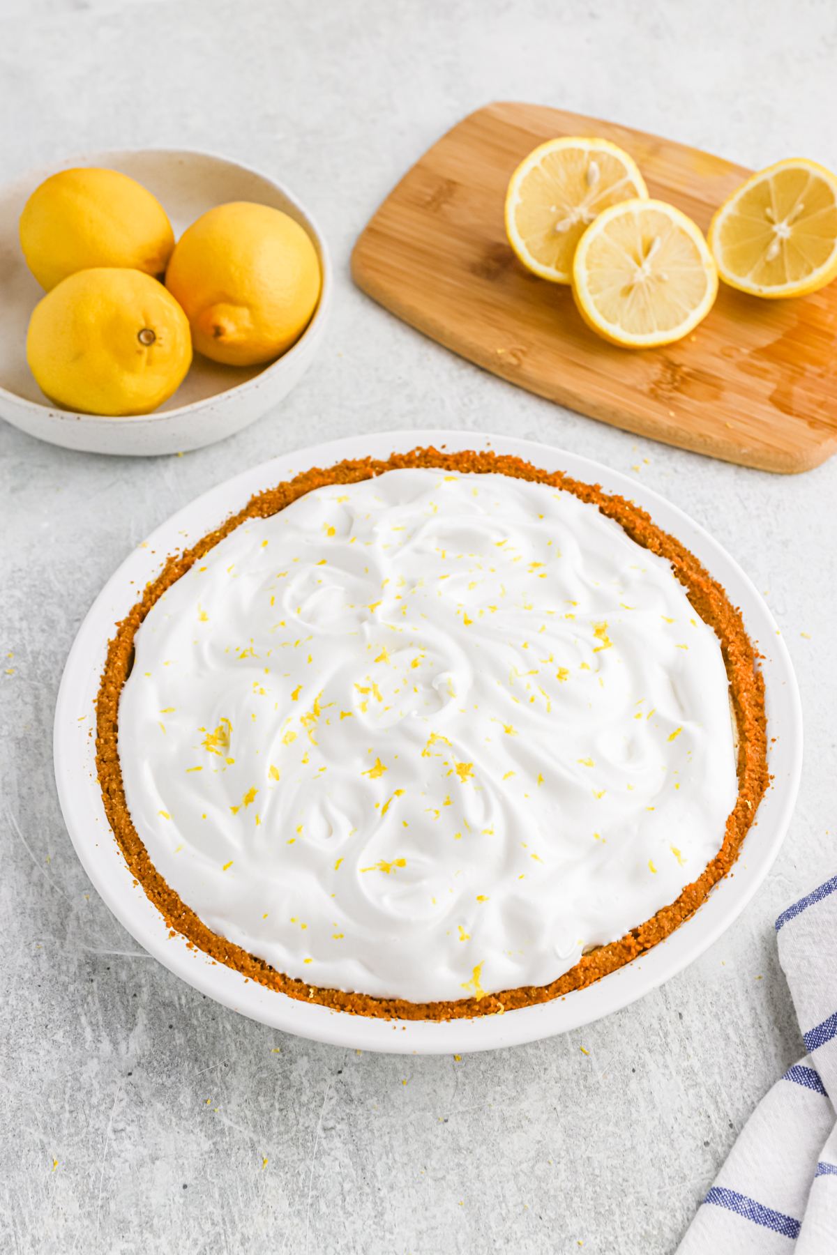 a lemon icebox pie with lemons in the background